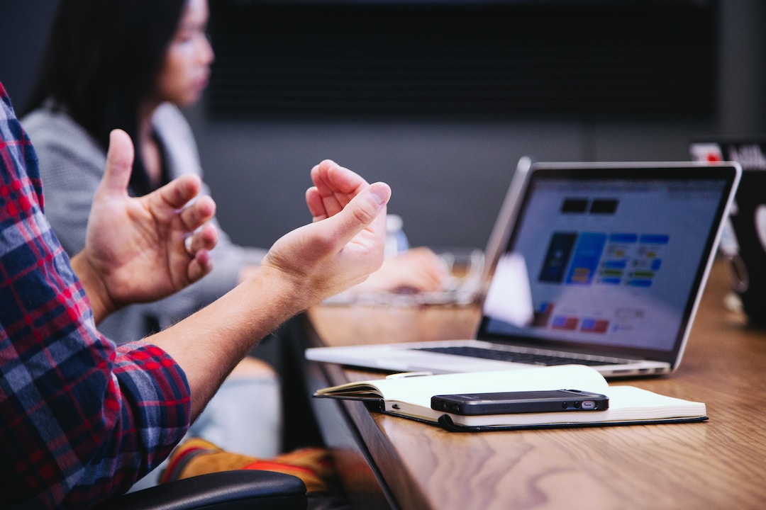 A business professional presents KPI metrics at a business meeting while sitting at a conference table